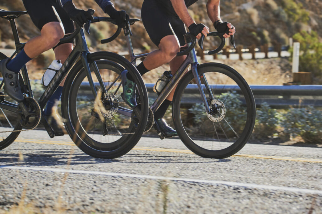 Twee fietsers rijden side-by-side op hoge snelheid op hun Giant TCR Advanced racefietsen, een toonbeeld van allround performance - verkrijgbaar bij Monsieur Vélo.
